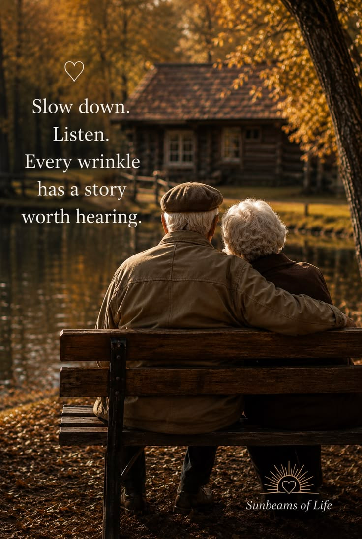 An older couple sitting together on a park bench beside a quiet lake in autumn, with the message Every wrinkle has a story worth hearing.