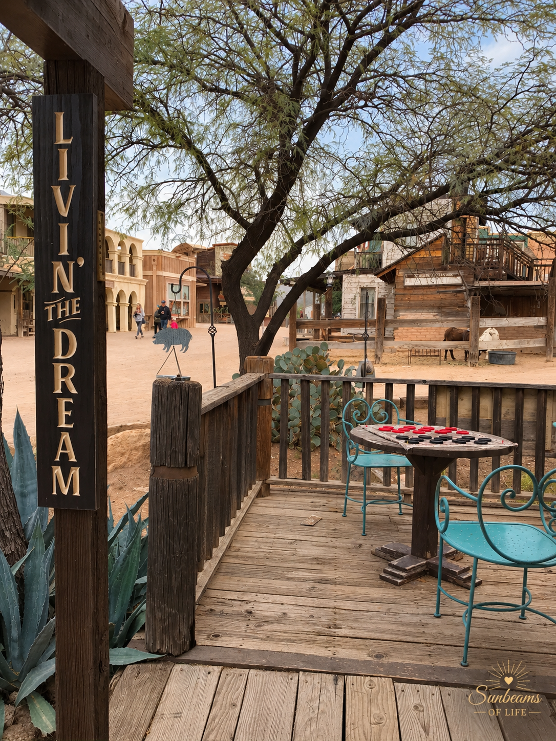 A weathered Old Tucson porch with a sign reading Livin' the Dream, overlooking a dusty Western street.