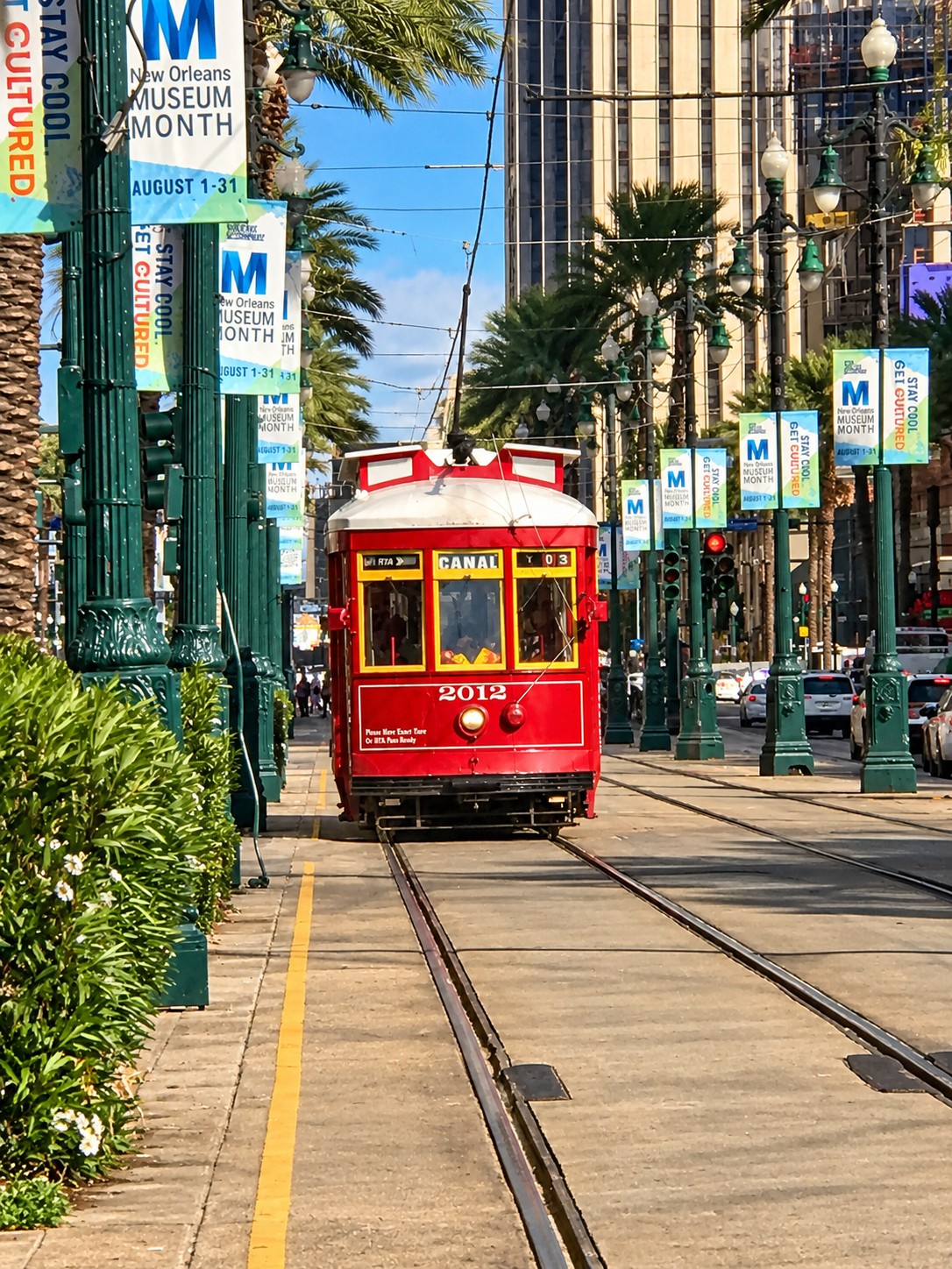 A bright red streetcar traveling through downtown New Orleans.